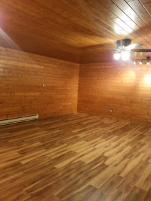 basement with laminate flooring and wooden walls and ceilings