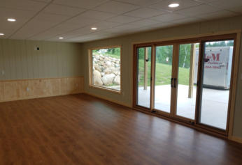 refinished basement with laminate flooring and paneling